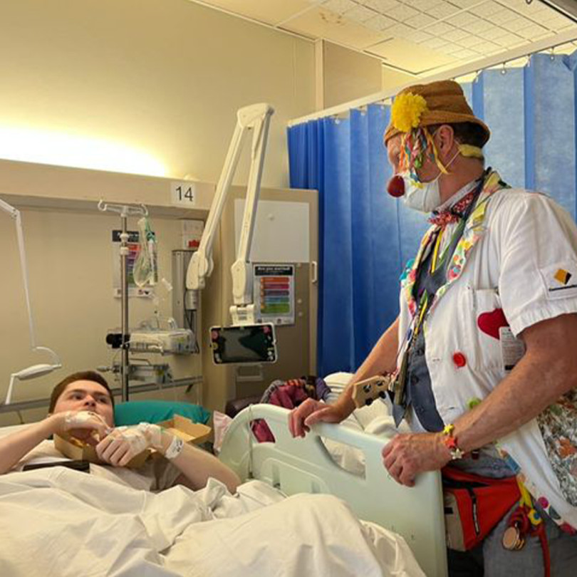 A clown doctor visiting a patient in hospital.